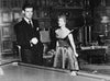 A scene from Caught (1949) DVD shows a man in a dark suit and a woman in an evening gown by a billiard table, radiating 1940s Hollywood glamour amid ornate wood paneling and a fireplace.