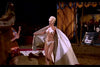 A woman in a showgirl costume and white cape strides through a circus ring, evoking vintage film style—just like scenes from Circus of Horrors (1960), now available on DVD.