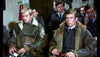 A group of men in bomber jackets and uniforms sit together looking serious, reminiscent of scenes from "Mosquito Squadron (1969)" DVD, a classic World War II aviation film.