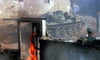 A tank rolls through a war-torn, burning building as a soldier hides behind debris and smoke fills the scene—reminiscent of rare war films like the Wheels of Terror (1987) DVD.