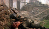 A soldier lies motionless on rubble in a war-torn room, his helmet and arm outstretched. In the background, a tank is partially visible—evoking the intense realism of Wheels of Terror (1987) DVD.