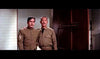 Two men in military uniforms stand by a door labeled "Recruiting Office," reflecting the camaraderie seen in "The Long Gray Line (1955)" DVD, as one appears serious while the other offers support.