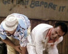 Two men, one in a white hat and blue shirt, the other in a white suit, laugh before graffiti reading "Get high before it." The scene feels straight from the Snake Eater (1989) DVD.