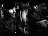 Two men in helmets and uniforms sit intently in a dim control room, operating equipment—evoking dramatic scenes from "The Tanks Are Coming (1951)" DVD.