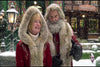 A woman and a white-bearded man, both in red coats with fur trim, stand smiling in falling snow—a festive scene perfect for the cover of The Christmas Chronicles 2 (2020) DVD.