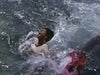 A man screams in pain as water splashes and red spreads near his legs—a dramatic scene reminiscent of The Sharkfighters (1956) DVD, a classic film available now for collectors.