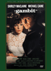 A movie poster for Gambit DVD (1966) features Shirley MacLaine and Michael Caine dressed in formal attire, standing closely together. This classic film is a standout among rare movies on DVD, with the title "Gambit" and the stars' names at the top of the poster, while additional credits are displayed at the bottom.