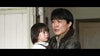 A man with a distressed expression holds a concerned girl indoors by a white door—reminiscent of intense scenes in rare hard-to-find films like Godzilla Minus One (2023) on DVD.