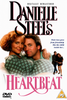 A man embraces a woman from behind as they both look at the camera. Text reads: Heartbeat DVD (1993) by Danielle Steel, with smaller text saying, “Their love grew from friendship like the child inside her...” This romantic comedy-drama is now available on DVD—one of the rare movies in this format—with DVD and PG symbols displayed at the bottom.
