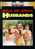 Three men in swim trunks stand side by side outdoors, flexing their arms and smiling. Above them, the text “Husbands” appears alongside the names of Ben Gazzara, Peter Falk, and John Cassavetes. This iconic image captures a memorable scene from *Husbands DVD (1970)*—a must-have for classic movie fans and collectors seeking this rare collaboration of legendary actors on DVD.