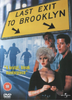 DVD cover for Last Exit to Brooklyn (1989) 2 Disc Set, showcasing a prominent yellow road sign, three men in the background, and a woman with platinum blonde hair and dramatic makeup in the foreground. This rare and hard-to-find movie is offered as a visually striking 2-disc special edition. The cover features the text: A brutal, bleak masterpiece.