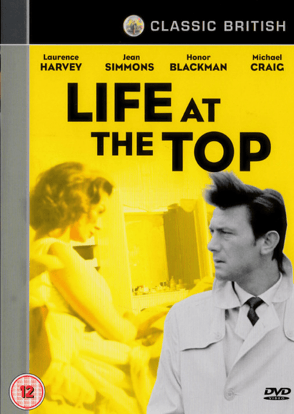 DVD cover for Life At The Top DVD (1965), a classic British drama film featuring Laurence Harvey. In the foreground, a man in a trench coat stands confidently, while a yellow-toned image of a woman appears in the background. The title and cast names—including the notable performance by Laurence Harvey—are displayed above in bold black and white text, making this Life At The Top DVD (1965) an essential addition to any collection.