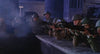 A group of soldiers wearing helmets and uniforms aim rifles over a stone barricade in a nighttime setting, with blue lighting and smoke swirling through the air—a striking scene reminiscent of rare classic films like the Gorgo (1961) DVD, sure to thrill monster movie collectors and kaiju DVD enthusiasts alike.