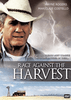 A man in a cowboy hat stands beneath a stormy sky lit up by flashes of lightning, while below, a classic American farm scene unfolds with a barn and windmill. The text “Race Against the Harvest” appears alongside the actors Wayne Rogers and Mariclaire Costello. Perfect for collectors of vintage classic movies on DVD, this evocative artwork beautifully captures the dramatic tension of American farm life featured in the 1987 film Race Against The Harvest DVD.