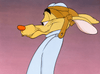 A cartoon coyote in aviator gear with droopy eyes and a tired expression stands sideways against a gradient pink and purple background, evoking the classic charm of vintage holiday characters from specials like “Raggedy Ann and Andy in The Great Santa Claus Caper” (1978) on DVD.