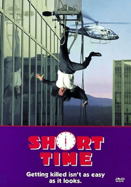 A man in a suit hangs upside down from a window washer platform, while a helicopter hovers nearby. The caption says, "SHORT TIME. Getting killed isn’t as easy as it looks." This rare DVD features the 1990 film *Short Time*, starring Dabney Coleman—a must-have for collectors looking for the Short Time DVD (1990).
