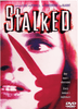 A terrified woman’s red-lit face is shown as a knife-wielding hand hovers near her cheek. The bold title STALKED appears above. Text reads: One man’s obsession. Every woman’s nightmare. Stalked DVD (1994) is a chilling thriller that collectors have sought after, now available along with other rare movies on DVD.