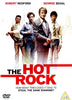 The Hot Rock (1972) DVD cover features four men in 1970s outfits suggesting a heist, set against city buildings. Robert Redford’s name appears at the top, with the film’s title displayed at the bottom.