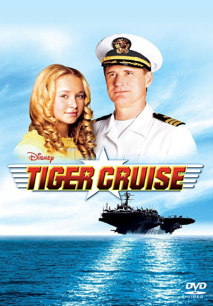 A blonde girl and a man in a white naval uniform stand together above the title Tiger Cruise, with an aircraft carrier sailing on blue water below them and a bright blue sky in the background—making the Tiger Cruise (2004) DVD perfect for fans of heartfelt military family movies or collectors searching for rare classic DVDs.