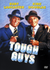 Two older men in suits and hats, smiling and holding guns, stand side by side on the cover of the Tough Guys DVD (1986). The actors’ names, Burt Lancaster and Kirk Douglas, appear above their heads, while the title “Tough Guys” is boldly displayed below them—capturing the essence of this classic train-robbery film.