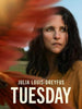 A woman with long dark hair gazes into the distance as red feathers blur the left side of the image. The text reads JULIA LOUIS-DREYFUS TUESDAY. Behind her, a grassy field and trees set a scene reminiscent of classic films, all featured in Tuesday (2023) DVD—a timeless addition to fantasy drama DVD collections.