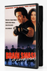 DVD case for Brain Smasher...A Love Story featuring Andrew Dice Clay and a woman in the foreground and a group of men in hats and coats in the background, with the text Rescue a Super-Model. Battle killer Ninjas. Save the world. No problem!!.