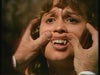 Two hands pull up a person's upper lip to reveal large, fake vampire fangs—an anxious expression reminiscent of the Count Dracula (1977) DVD cover.