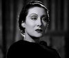 Black-and-white portrait reminiscent of classic horror icons, featuring a woman with slicked-back hair, dramatic makeup, and dark lipstick, wearing a dark garment and gazing seriously to the side—capturing the enigmatic allure embodied by “Dracula’s Daughter (1939)” DVD.