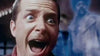 A man with wide open eyes and mouth stares in shock or fear, as a blue, ghostly figure looms in the background—just like a scene from “The Frighteners (1996)” DVD.