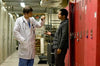 A doctor in a white coat speaks with a casually dressed man by red lockers in an industrial-lit hallway, evoking the suspenseful atmosphere of The Good Doctor (2011) DVD.