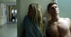 A woman in a hospital gown and a shirtless man stand tense against a hallway wall, as if hiding—a suspenseful moment from Just What the Doctor Ordered (2021) DVD, ideal for fans of crime thriller DVDs.