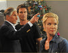 Three people stand near a decorated Christmas tree; an older man points while a man in black and a blonde woman in denim look in different directions with serious expressions, capturing a scene reminiscent of the classic family moments found in “Holiday Road Trip (2013)” on DVD.