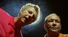 Two men in brightly colored shirts are looking down toward the camera, dramatic lighting and a smoky background creating a halo effect behind them—just like a scene from the Australian classic *Wake in Fright (1971)* DVD, the kind of rare film that leaves a lasting impression.