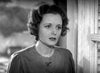 A woman with wavy hair, dressed in a blouse and standing indoors with a concerned expression, appears in this black-and-white image evocative of scenes from classic films—such as those found on the *Dodsworth (1936) DVD*.