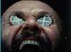 A man with his mouth open has round mirrors over his eyes, reflecting a windowpane pattern; his face appears tense and sweaty in this scene from *Wake in Fright (1971) DVD*, an Australian masterpiece that is a must-have for collectors seeking rare movies on DVD.