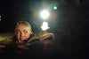 A terrified person with short blonde hair screams while half-submerged in dark water at night—perfect for fans of thrilling crocodile adventures like Rogue (2007) DVD.