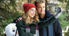 A woman in a red knit hat and a man in a dark coat snap a joyful selfie outdoors, grinning with a snowman and trees behind them—a picture-perfect moment reminiscent of the heartwarming scenes from “On the Twelfth Day of Christmas (2015)” DVD, capturing the magic of holiday romance.