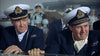 Two naval officers in uniform and white caps stand on a ship’s deck, looking ahead seriously—a scene evoking classic World War II films like Pursuit of Graf Spee (1956) DVD. Crew members and ship equipment appear in the background.