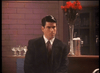 A man in a dark suit sits before a brick wall, beside a bar lined with red flowers and champagne glasses—capturing the classic mafia movie vibe seen in rare films like Killer Instinct DVD (1992).