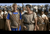 Two men in Roman-style costumes face soldiers in armor in a scene from Amazons of Rome (1961) DVD—one wears a blue tunic with bronze armor, while the other is dressed in a simple beige outfit.