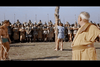 A person is bound to a post before armored soldiers as two men observe—a dramatic moment from "Amazons of Rome (1961) DVD," inspired by classic tales of legendary Roman women warriors.