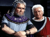 Two older men with gray hair and beards wear ornate robes—one in a serious purple cloak, the other in red listening intently—evoking scenes from vintage classics or a rare find like The Minotaur (1960) DVD.