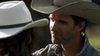 A man in a cowboy hat gazes warmly at a woman in a white hat, both bathed in natural light—evoking the romance and adventure of an American West movie. Experience this timeless spirit with The Real West (2024) DVD.