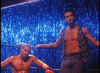 Two muscular men face off in a boxing ring against a blue sequin backdrop—a scene from the classic kickboxing movie "Final Impact (1992)" DVD, featuring one shirtless fighter with red gloves and another in an open vest and jeans by the ropes.