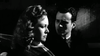 A somber woman sits in profile as a concerned man looks at her, capturing the dramatic tension of classic horror in this black and white scene from "Blood of Dracula (1957)" DVD.