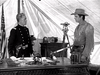 Two men stand inside a tent office—one in military uniform at a desk, the other in frontier clothing holding a tomahawk. An American flag and surveying gear set the scene for a classic like The Yellow Tomahawk (1954) DVD.