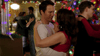 Couples dance at a festive holiday party with bright Christmas lights and a decorated tree, as rare DVDs like A Heavenly Christmas (2016) DVD play in the background, creating a warm, joyful atmosphere.