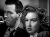 A black-and-white close-up of a man with a cigarette and a woman with wavy hair, both staring intently forward—ideal for fans of classic films and collectors seeking rare titles like Apology for Murder (1945) DVD.
