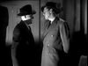 Two men in suits and hats face each other in a dimly lit room, creating tension. Apology for Murder (1945) DVD is a rare, must-have classic for suspense fans seeking hard-to-find movies and gripping noir scenes.