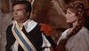 A man in a dark uniform with a blue and gold sash stands beside a woman with long, brown braided hair in a white blouse against a rustic stone wall—echoing the adventurous spirit of "Morgan The Pirate DVD (1960).